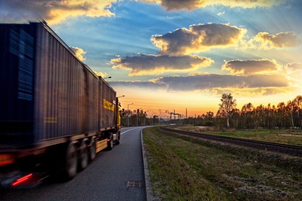 Blurred truck on country road at sunset